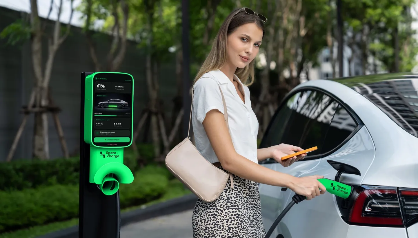 Woman plugging her white electric car into a SpareCharge home charger