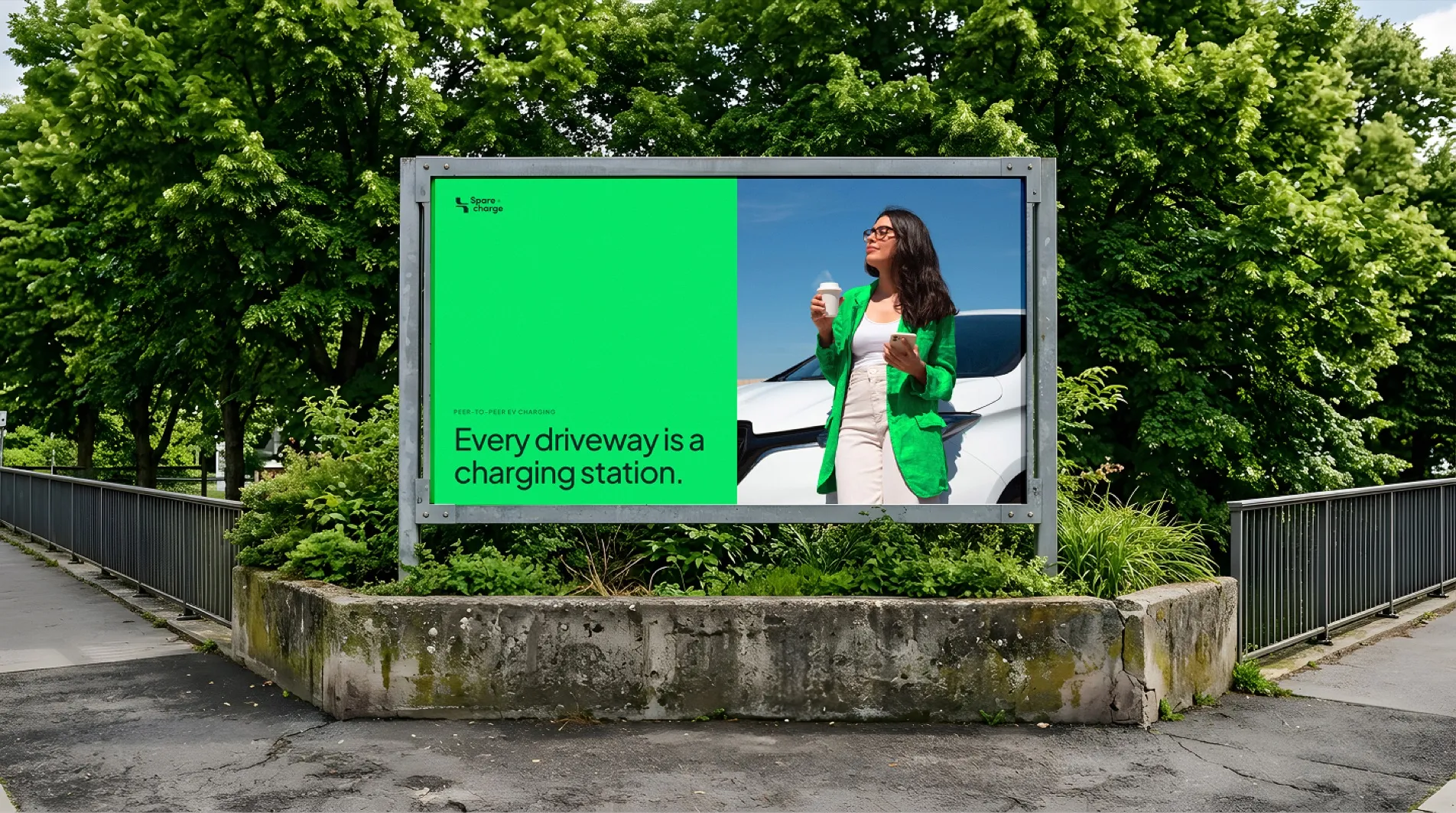 SpareCharge billboard in a park reading “Every driveway is a charging station”
