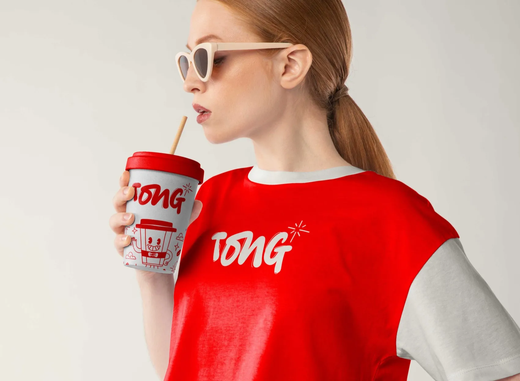 Model drinking from a red Tong coffee cup in a red Tong sweatshirt