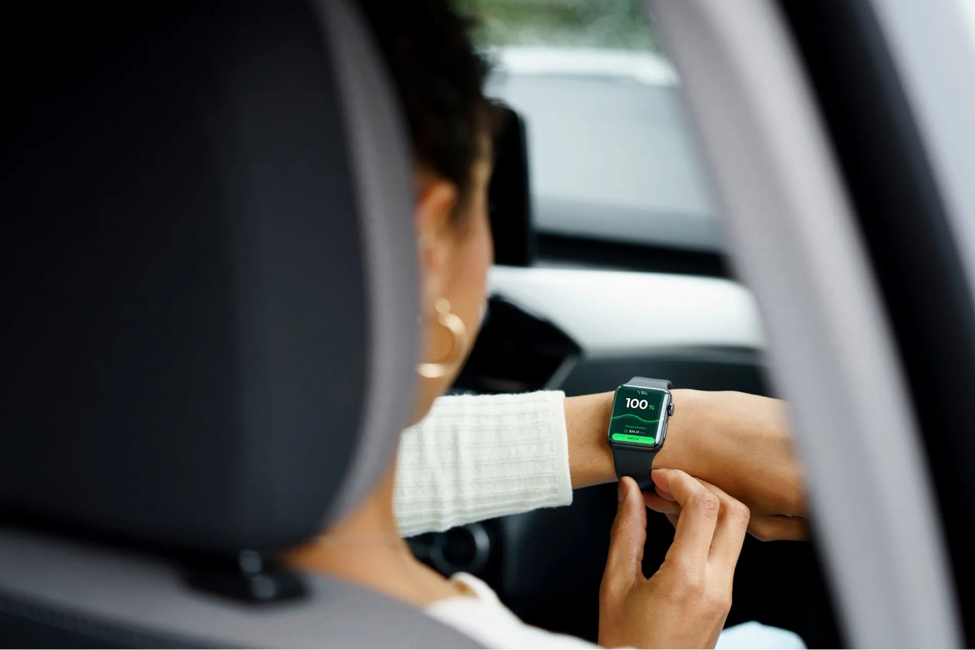 Driver checking a charging request on a smartwatch inside the car