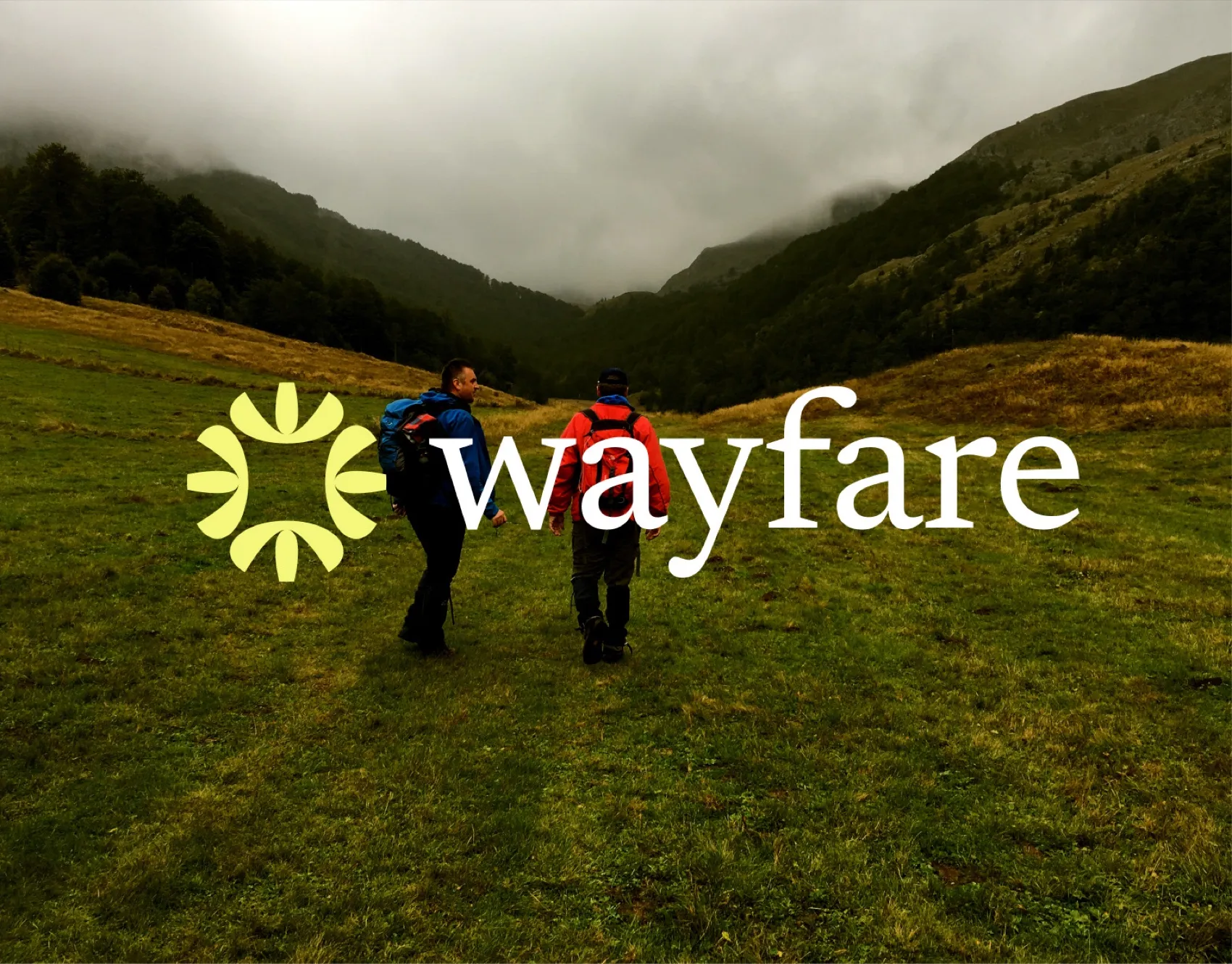 Wayfare logo with a sun symbol over two hikers in a green valley