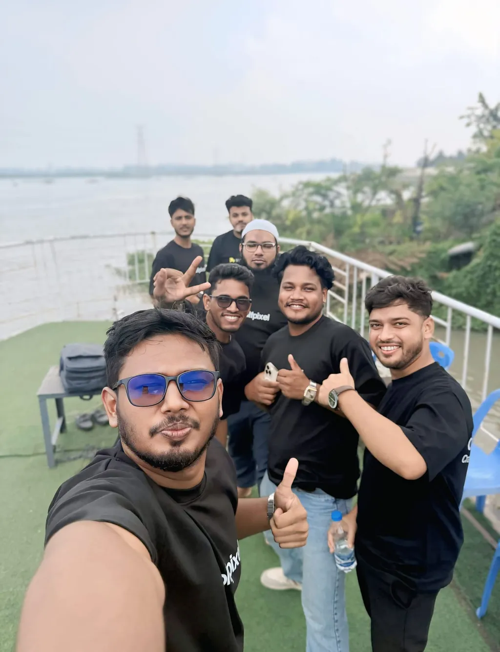 A team selfie on a riverside terrace