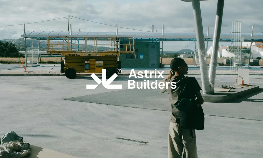 Astrix Builders logo over a photo of a man looking across a construction site