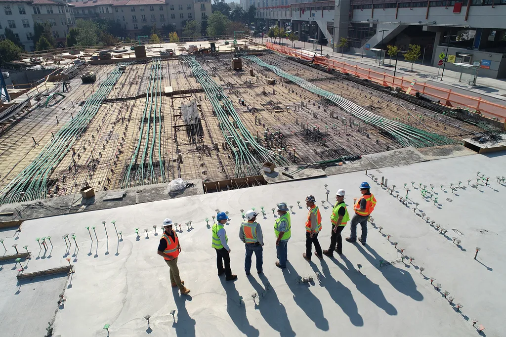 Construction crew in hi-vis standing on a large site seen from above