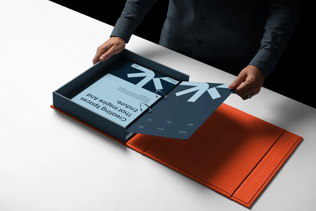 Hands opening a navy Astrix Builders presentation box with an orange lining