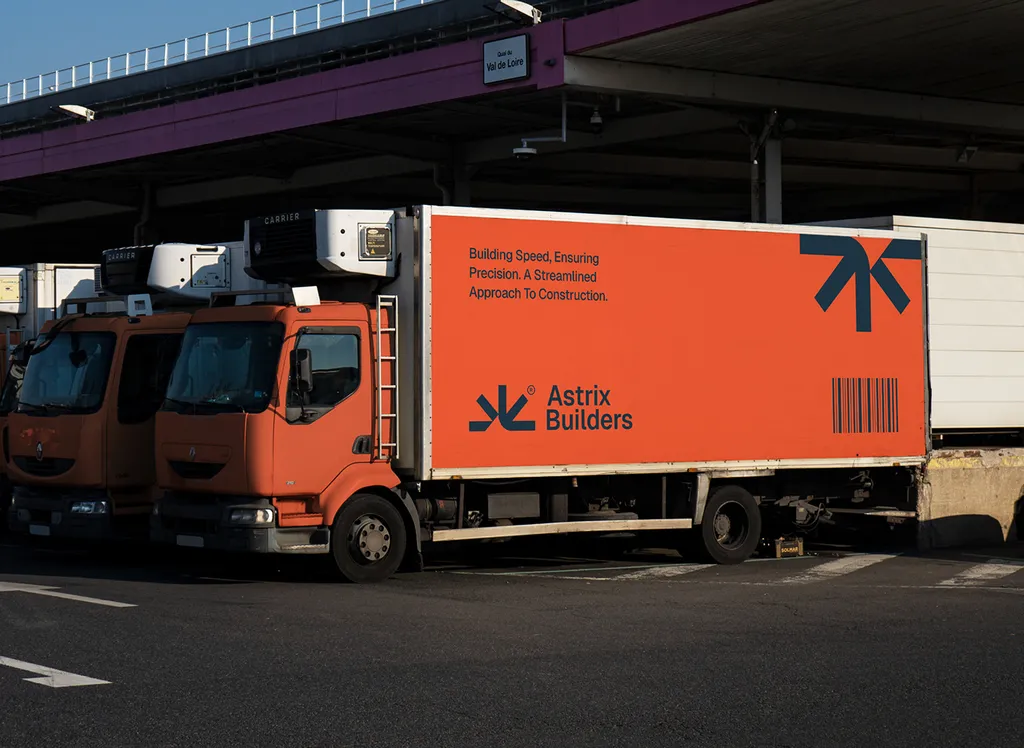 Orange Astrix Builders box trucks parked at a loading bay
