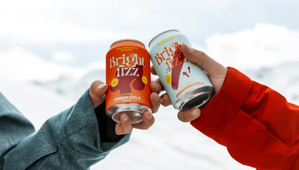Two hands toasting with Bright Fizz cans against a snowy sky