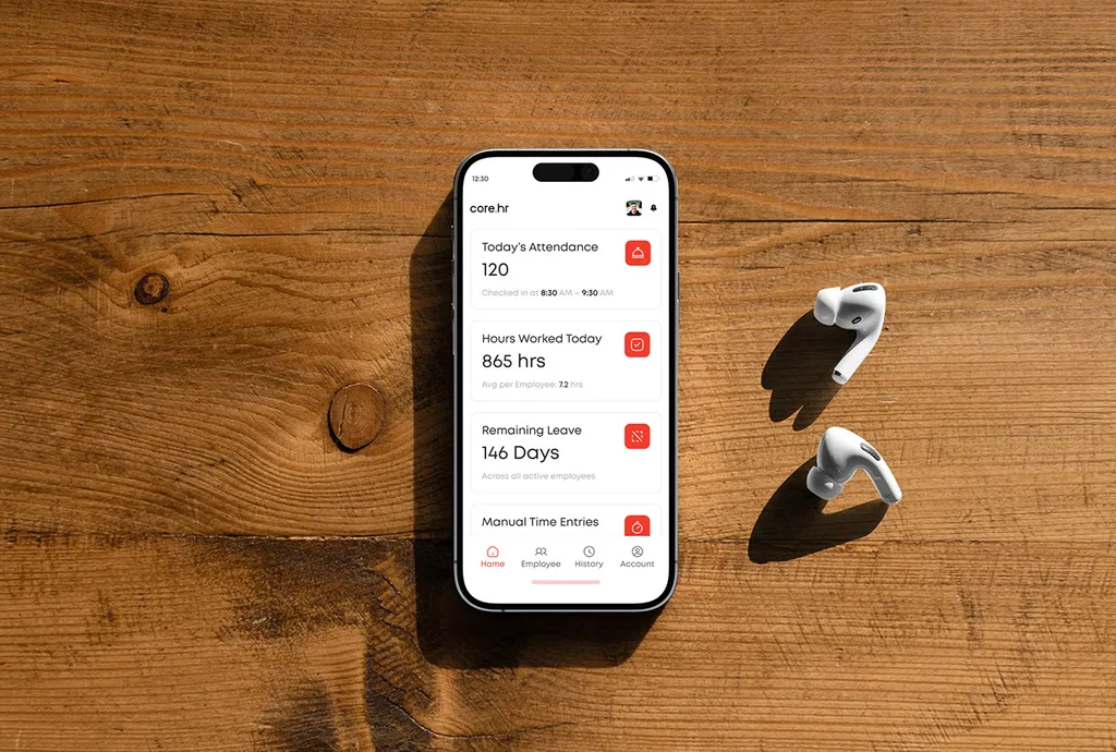 Phone on a wooden table with the core.hr attendance screen