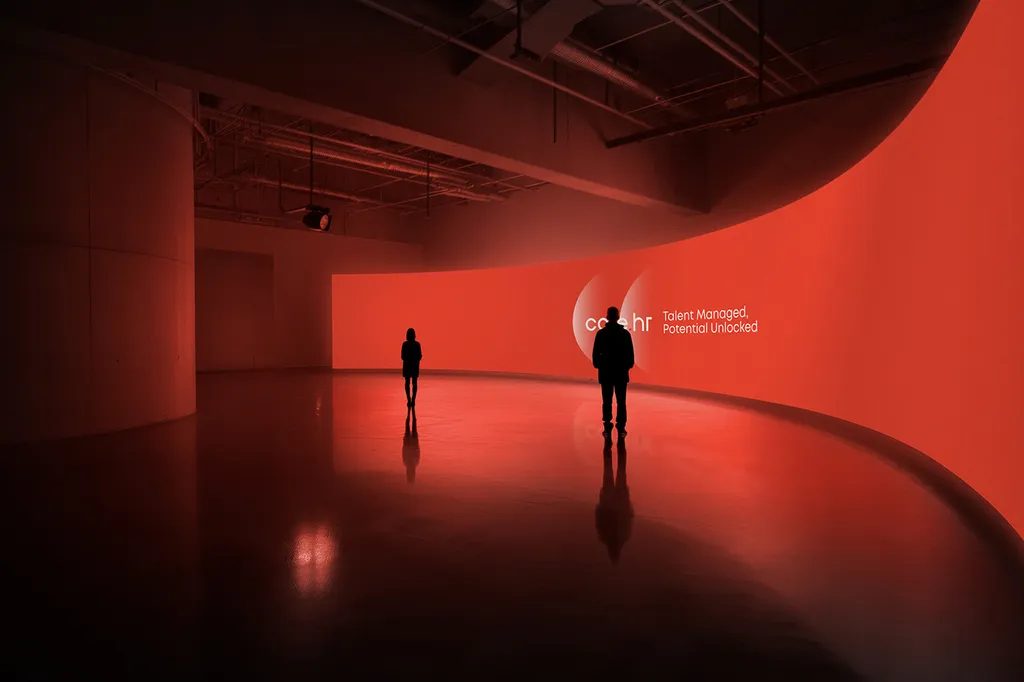 People standing in a dark event space lit in core.hr red