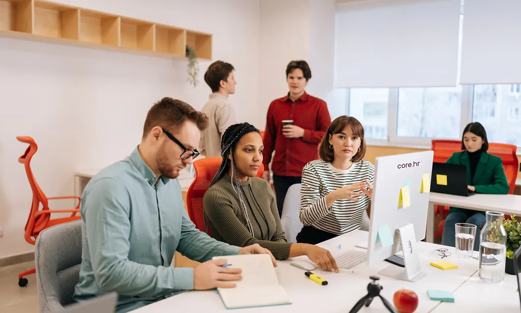 Team meeting around a desk in a bright office