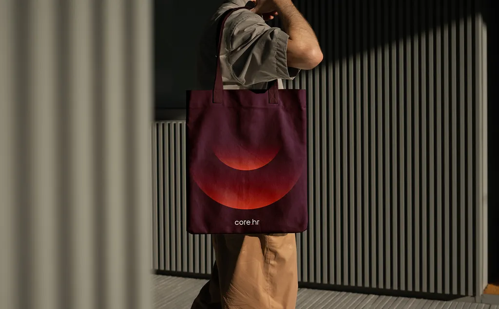 Person carrying a burgundy core.hr tote bag