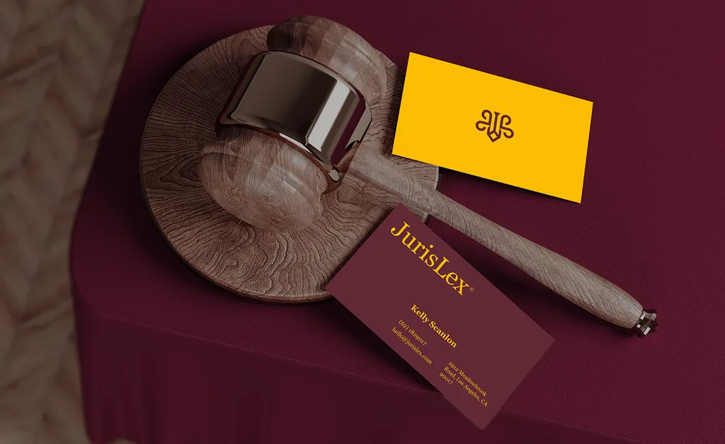 JurisLex business cards in burgundy and yellow lying on a wooden gavel and sound block