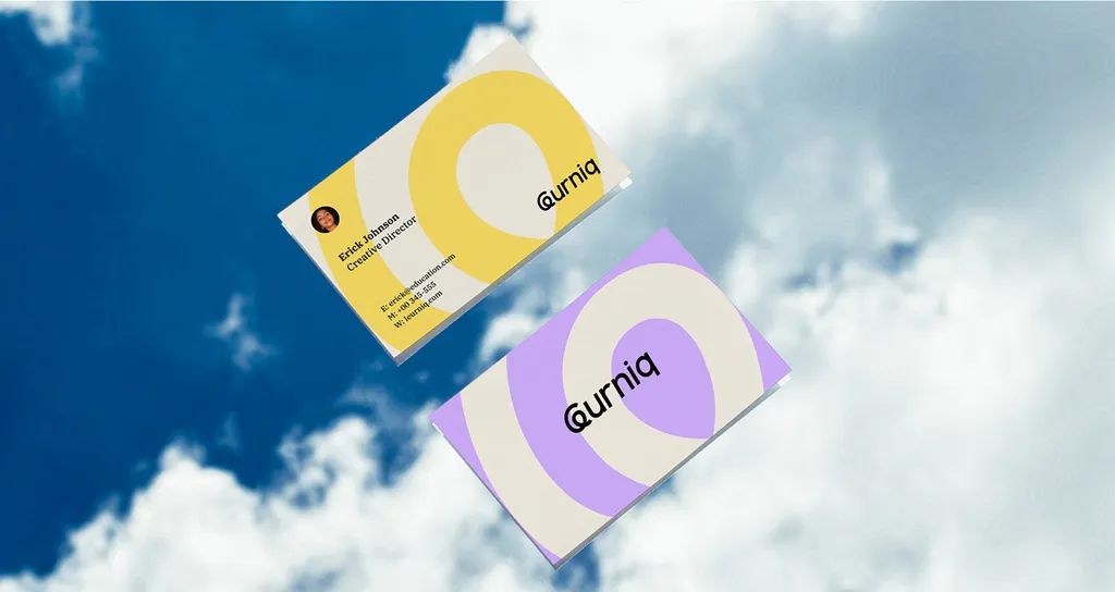 Two Leurniq business cards in yellow and lilac with large rounded rings, floating against a cloudy sky
