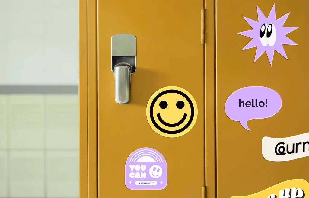 Leurniq stickers on a yellow locker: a smiley, a “hello!” speech bubble, a “You Can” badge and the wordmark