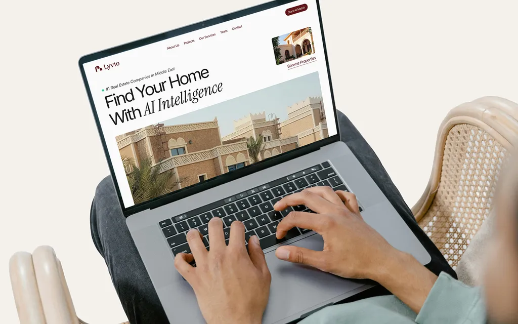 Laptop on a lap showing the Lyvio website: “Find Your Home With AI Intelligence”