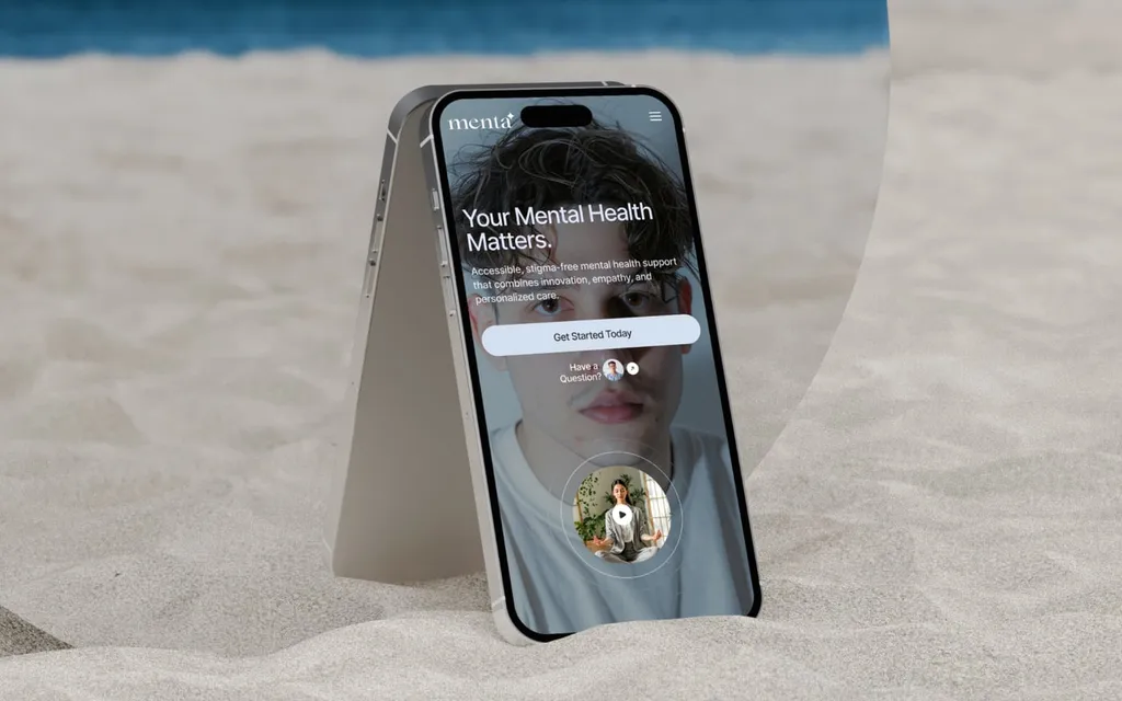 Phone standing in the sand showing the Menta website