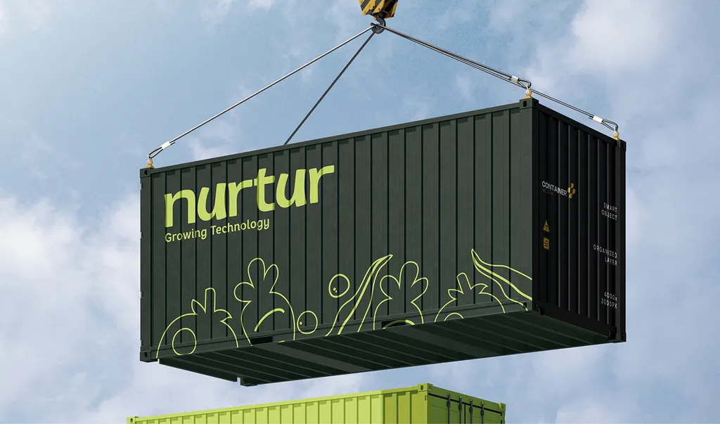 Nurtur dark green shipping container with the lime logo, Growing Technology and line-drawn vegetables, lifted by a crane