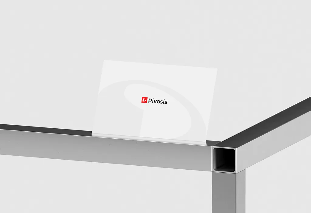 Pivosis card with the red logo and a large pale P outline, standing on the edge of a brushed metal frame