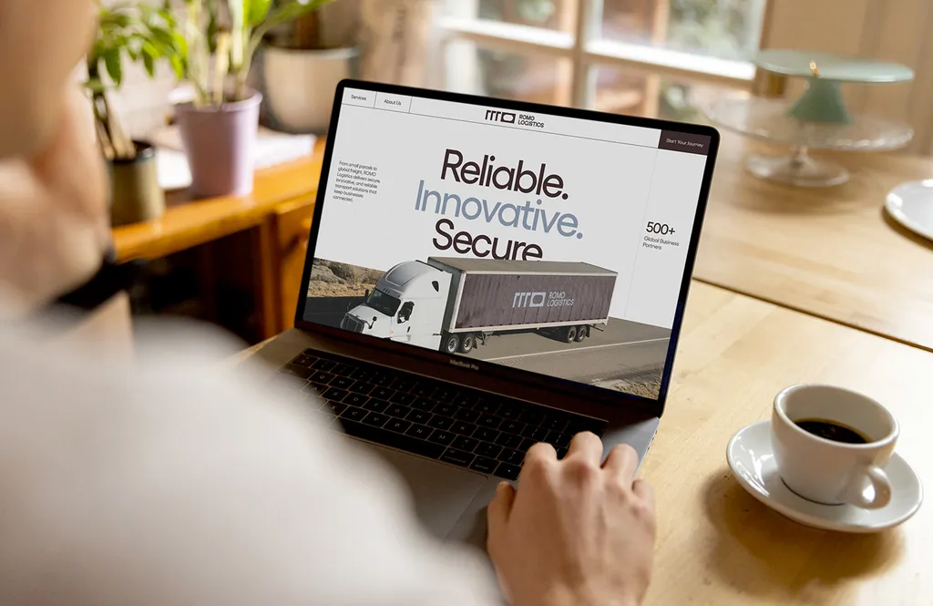 Laptop on a café table showing the ROMO website: “Reliable. Innovative. Secure.”