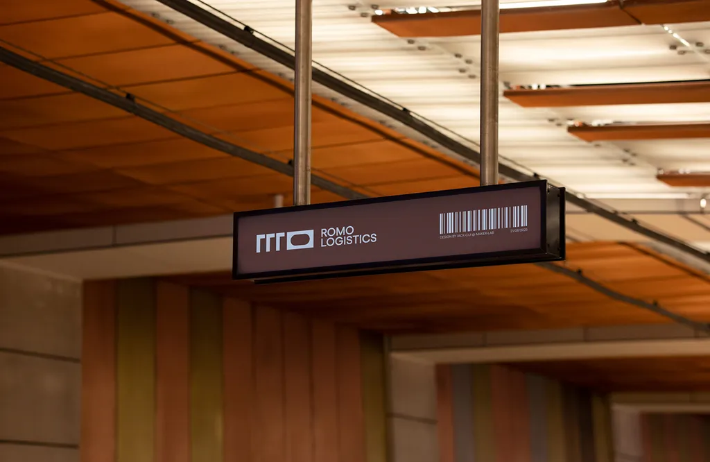 Hanging ROMO Logistics sign with a barcode under a wooden ceiling