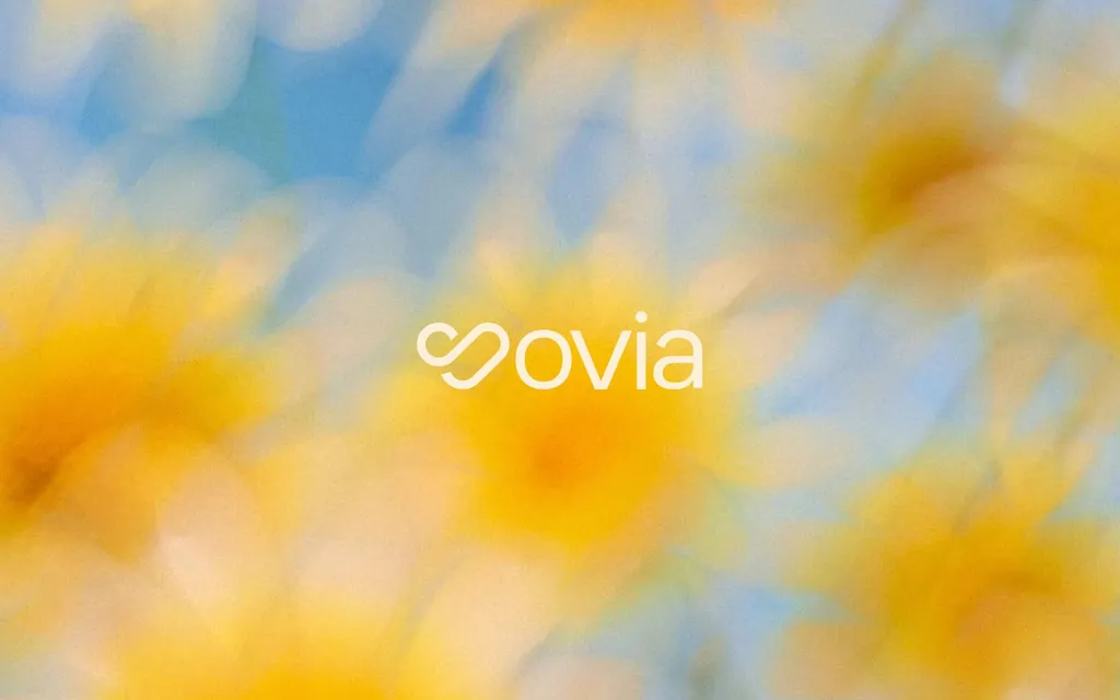 Sovia logo in white over soft blurred yellow flowers and blue sky