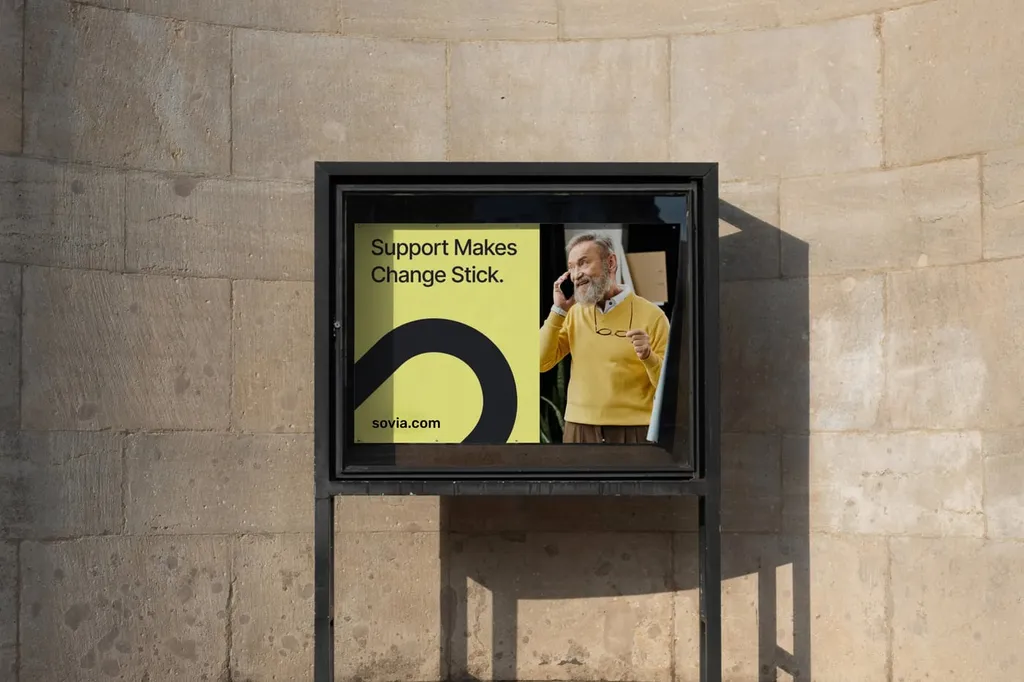 Framed street poster: “Support makes change stick.”