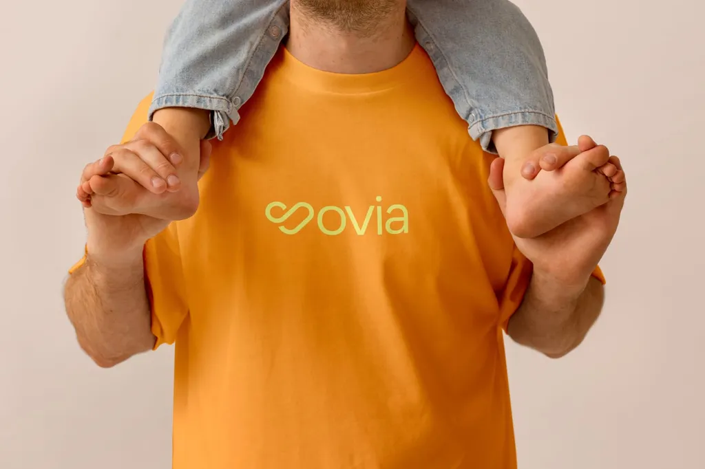 Orange Sovia T-shirt with a child sitting on the wearer’s shoulders