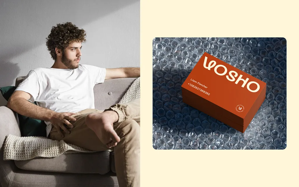 Man relaxing on a gray sofa next to a stack of rust orange Vosho business cards on bubble wrap