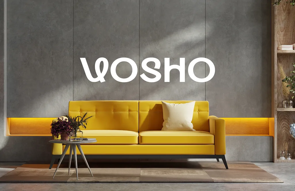 White Vosho wordmark on a gray concrete wall above a yellow sofa and a small side table with flowers