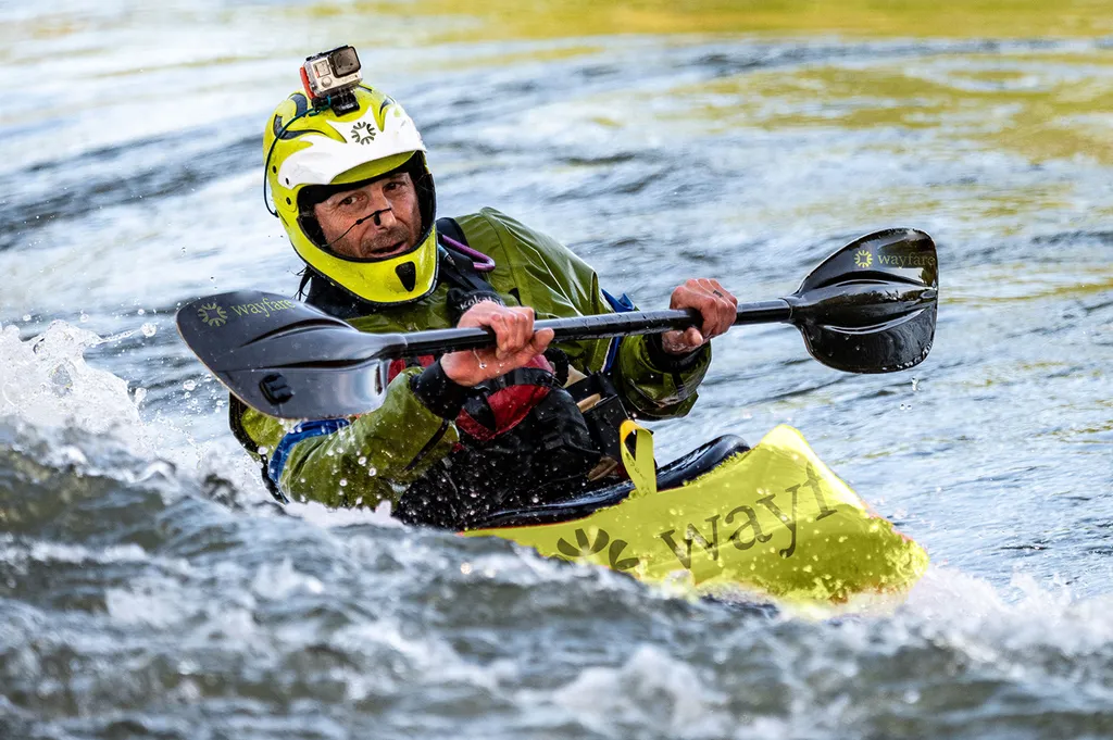 Kayaker in white water paddling a lime Wayfare kayak