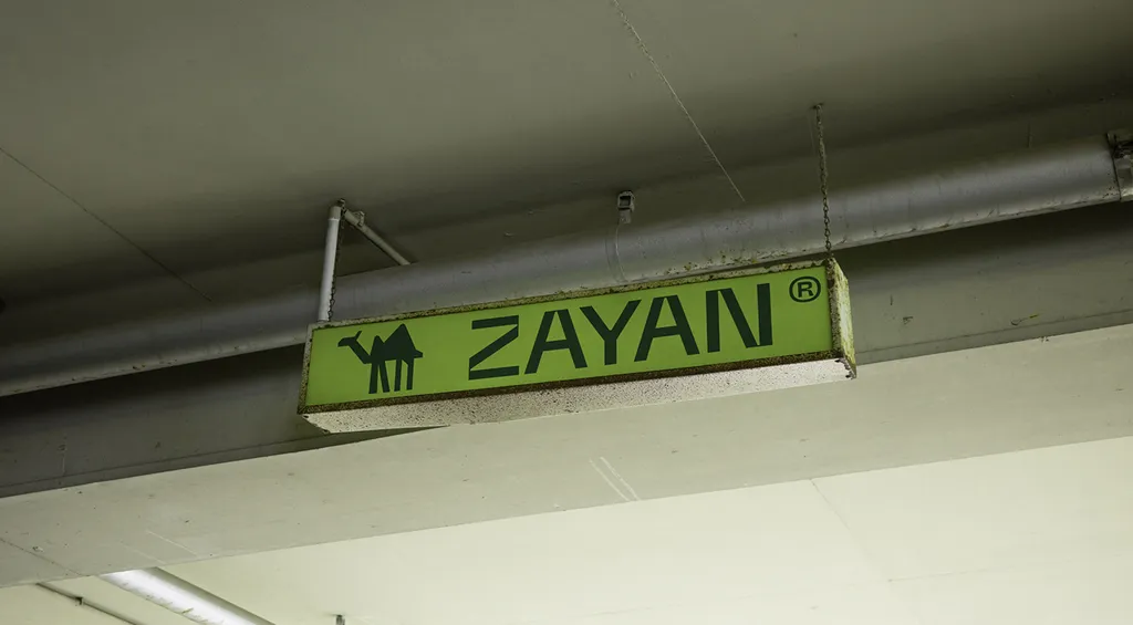 Lime ZAYAN light box sign in a concrete parking garage