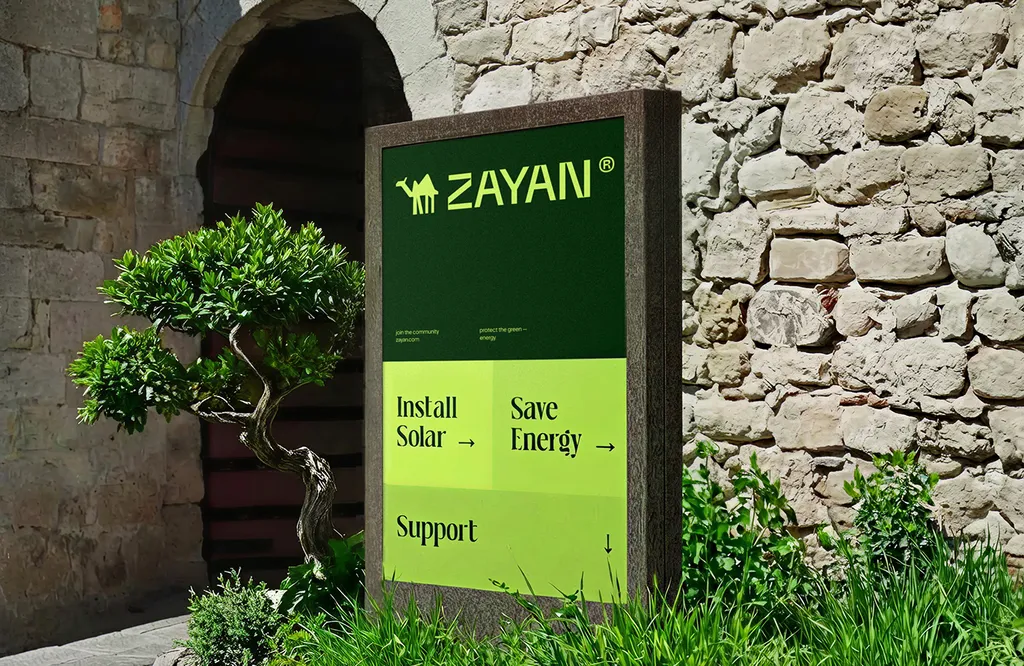 ZAYAN sign by a stone wall with “Install Solar” and “Save Energy”